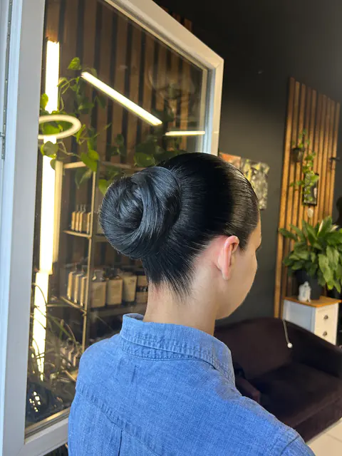 Tökéletesen simított, formázott konty fényes fekete hajon: alkalmi frizura a BLOOM Hair Salonban